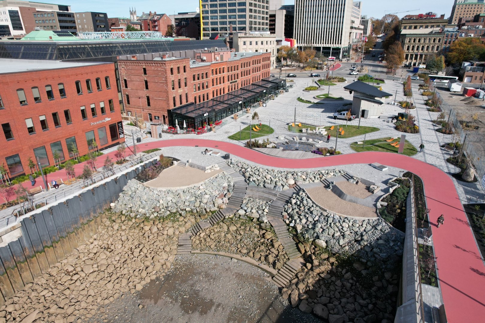 Aerial of a finished waterfront plaza with a red pathway