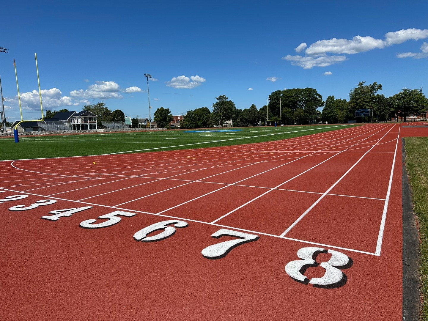 Ground-level view along the numbered starting lanes toward the field and grandstands