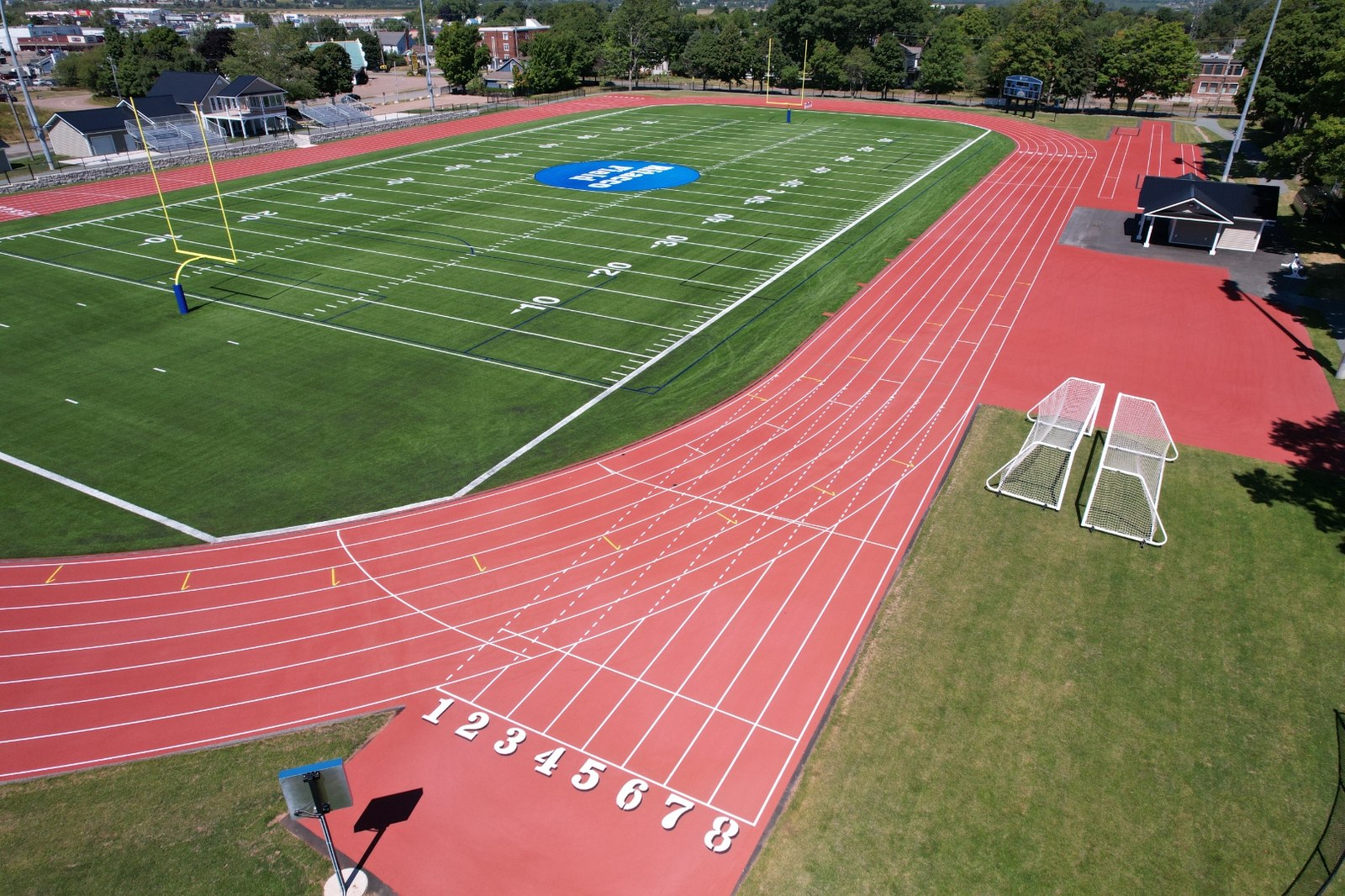 Low-angle view down the numbered starting lanes of the resurfaced eight-lane track